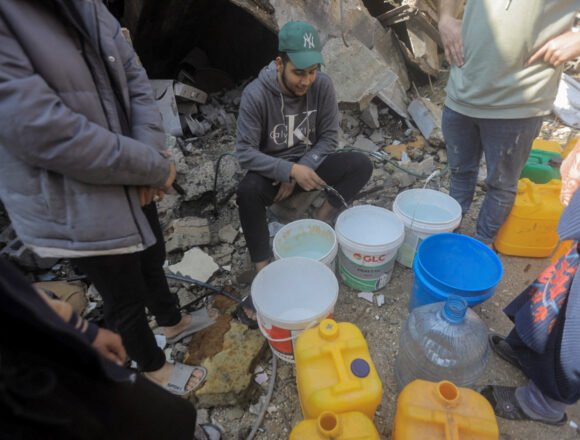 Palestinians collect water from a house destroyed by an Israeli strike, in Jabalia refugee camp in the northern Gaza Strip La Cooperación: una tirita colonial de Norte a Sur – TESH SIDI en Público