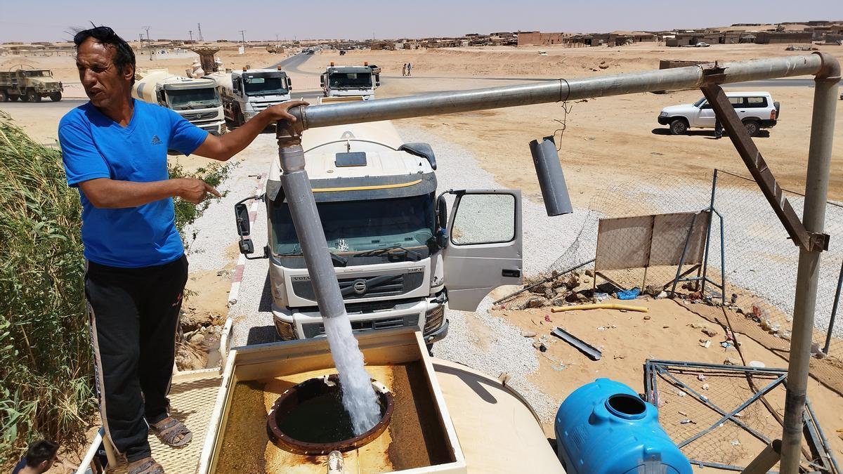 Un trabajador llena un depósito de agua que se va a distribuir entre la población.